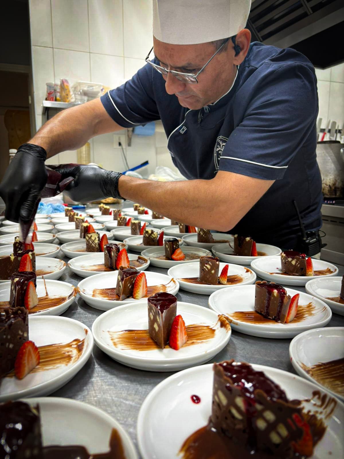 Chef Hugo Ferreira em ação na cozinha, finalizando pratos